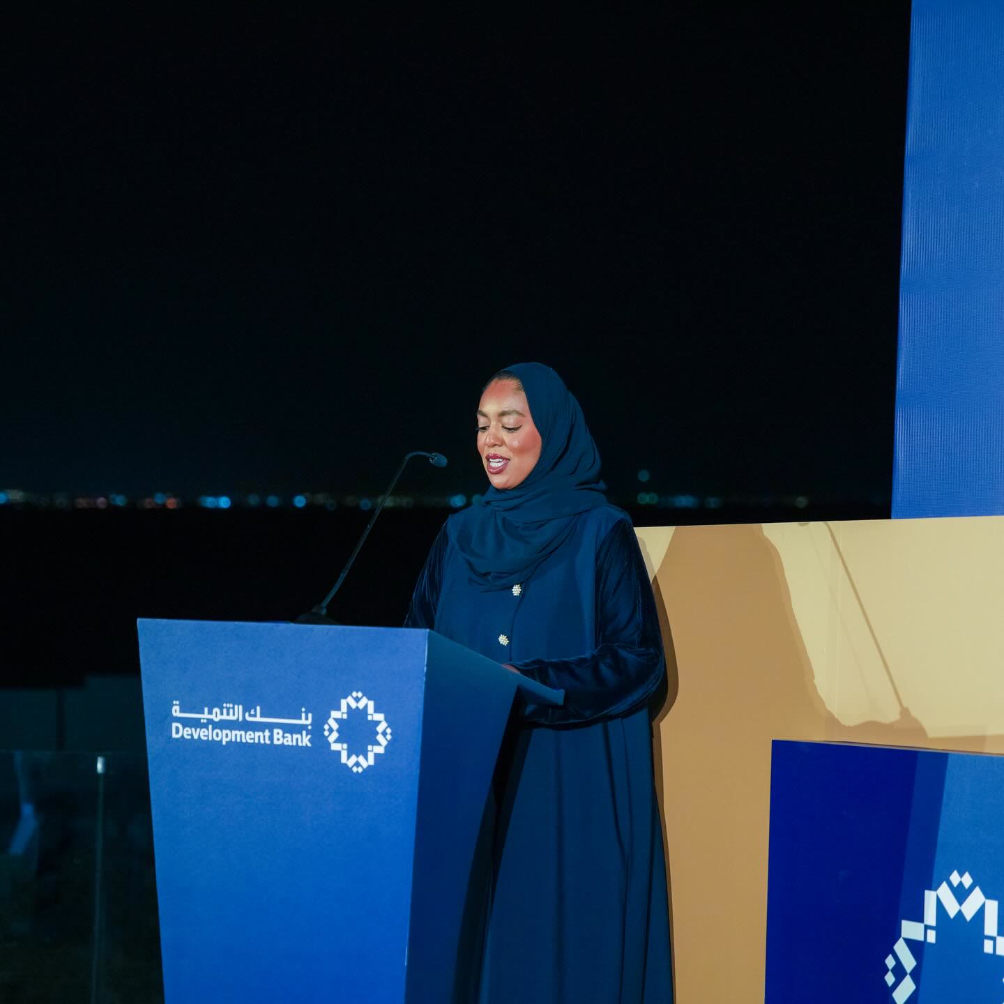 Asma at the podium at night